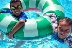 Two Carnarvon kids floating with a giant inflatable swim ring