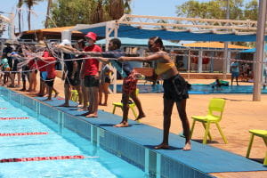 Aboriginal children doing the rope throw from the edge of the pool