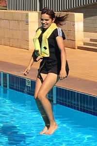 Hedland student jumping into a swimming pool wearing a PFD
