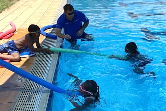 Students using pool noodles to reach rescue their peers at Warmun Remote Community Pool