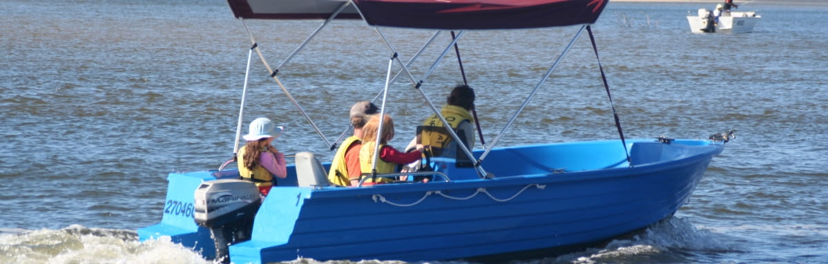 A family of safe boaters jet along the river in their small vessel