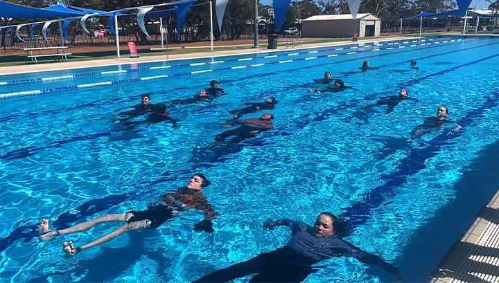 Students swimming on their back in the pool at Kambalda