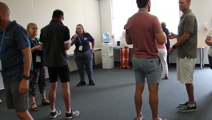 group of community trainers chatting in a training room