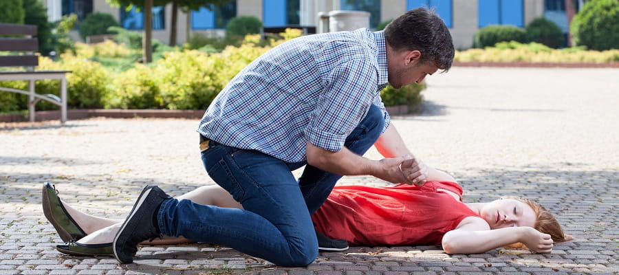man coming to the aid of an unconscious woman
