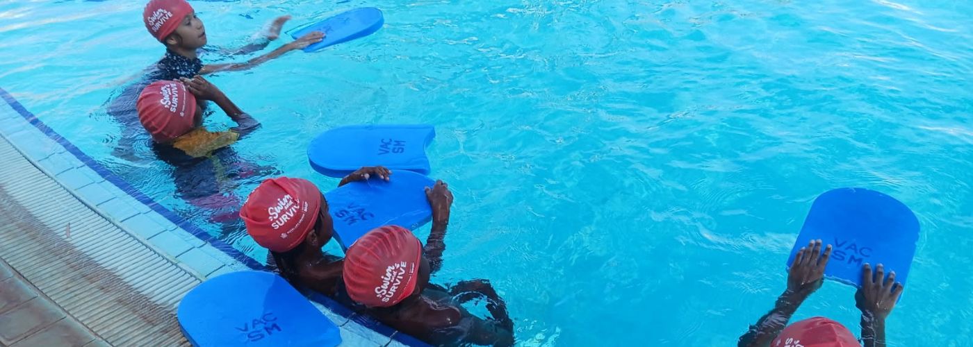 kids in the pool with kickboards
