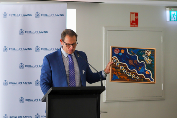 Royal Life Saving WA CEO Peter Leaversuch holds up the artwork