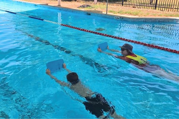 Teacher and student kicking in the water