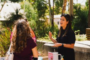 Tneale behind Be A Mermate stall talking to young woman
