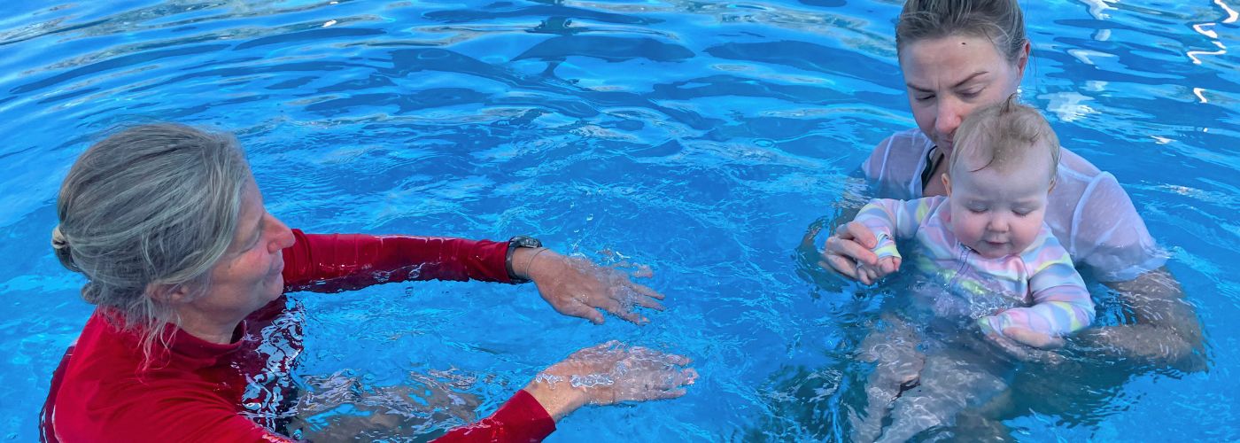 Instructor in pool with a mum and small child