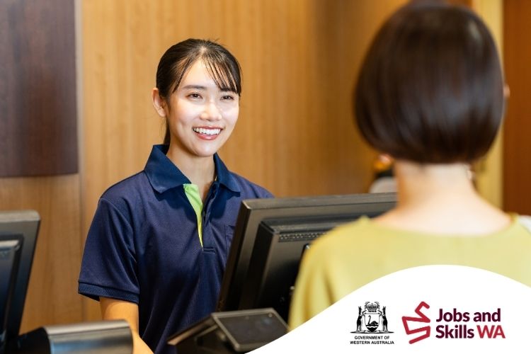 Aquatic and recreation centre customer service staff member assisting a customer at the front desk.