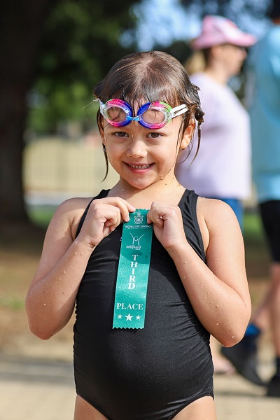 young girl holding third place ribbon at JLC State Titles