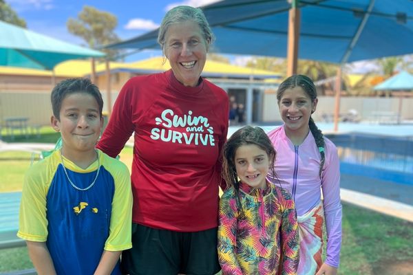 Smiling instructor with three children looking at the camera