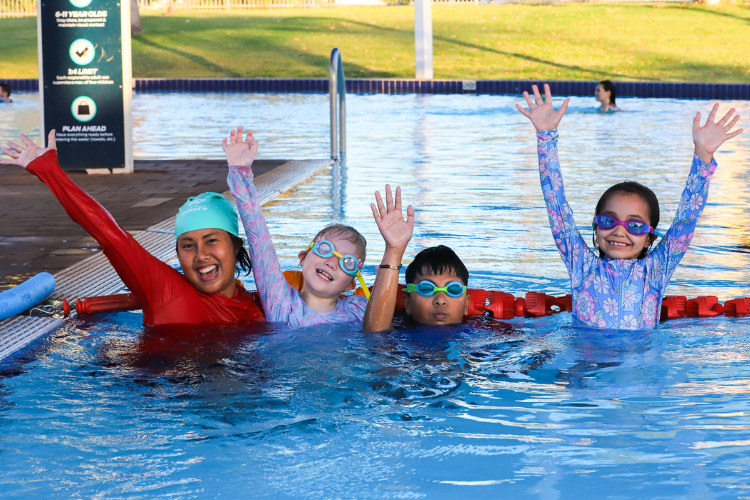 children at a swimming lesson in an outdoor pool