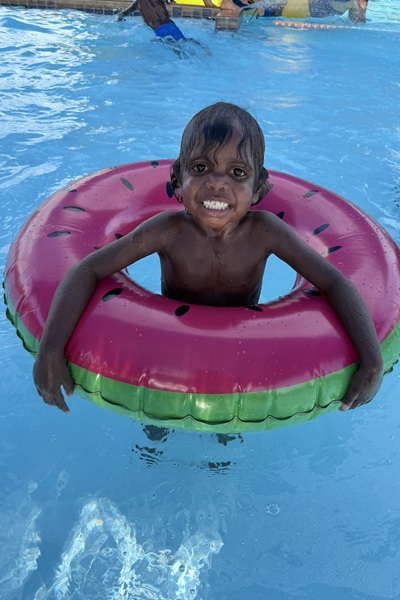 young Aboriginal boy in pool inflatable at Bidyadanga pool