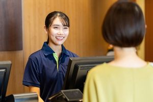 Aquatic and recreation centre customer service staff member assisting a customer at the front desk.