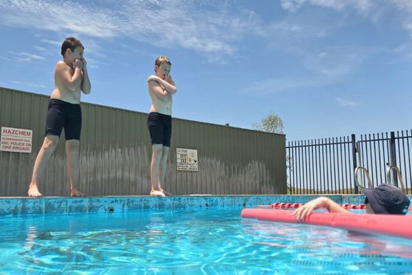 Two students jumping into the pool