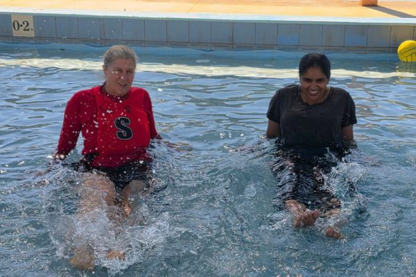 Instructor and woman kicking in shallow water