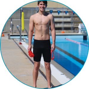 man wearing swimming trunks standing near a pool