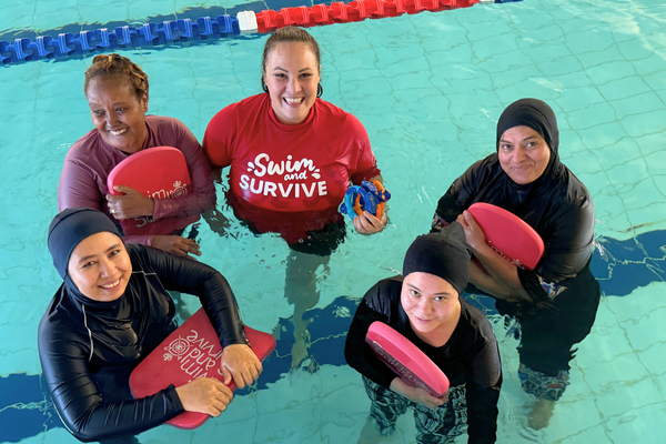 A Royal Life Saving WA Multicultural Women's Only swimming instructor stands with her students 