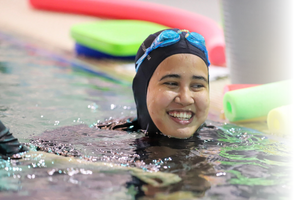 Woman smiles while standing in deep pool