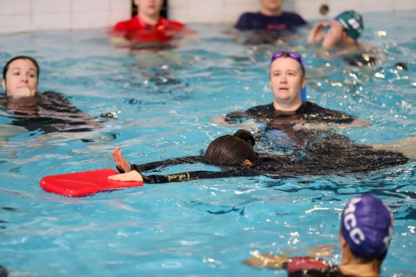 Swim teachers in the pool using kickboard