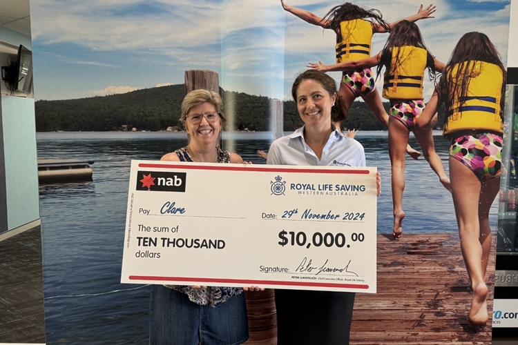 previous raffle winner holding giant cheque