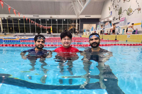 A Royal Life Saving WA Multicultural Men's Only swimming instructor stands with his students 