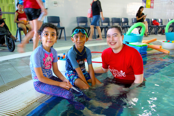 A Royal Life Saving WA Multicultural Youth swimming instructor sits with her students 
