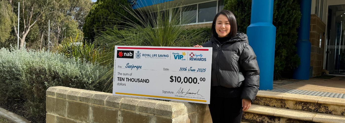 Sasi with her prize check outside the Royal Life Saving WA office