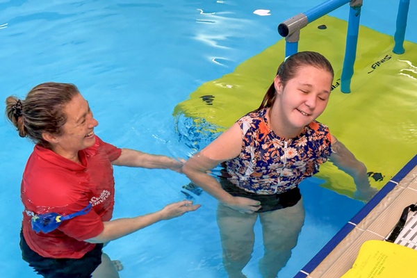 A blind SAIL participant is guided by her instructor in the pool