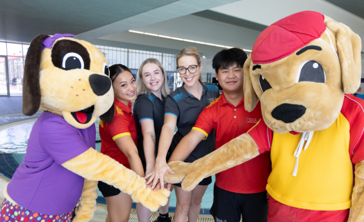 Water and Wendy mascots with their hands in with four pool lifeguards