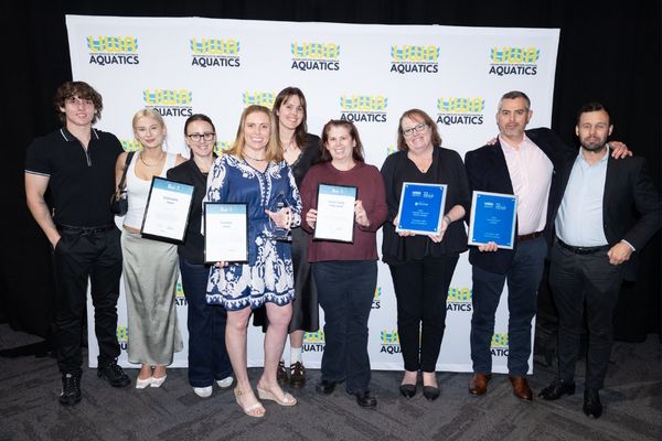 Group of organisational and facility award recipients holding certificates and trophies at the LIWA Aquatics WA Aquatic and Recreation Industry Awards.