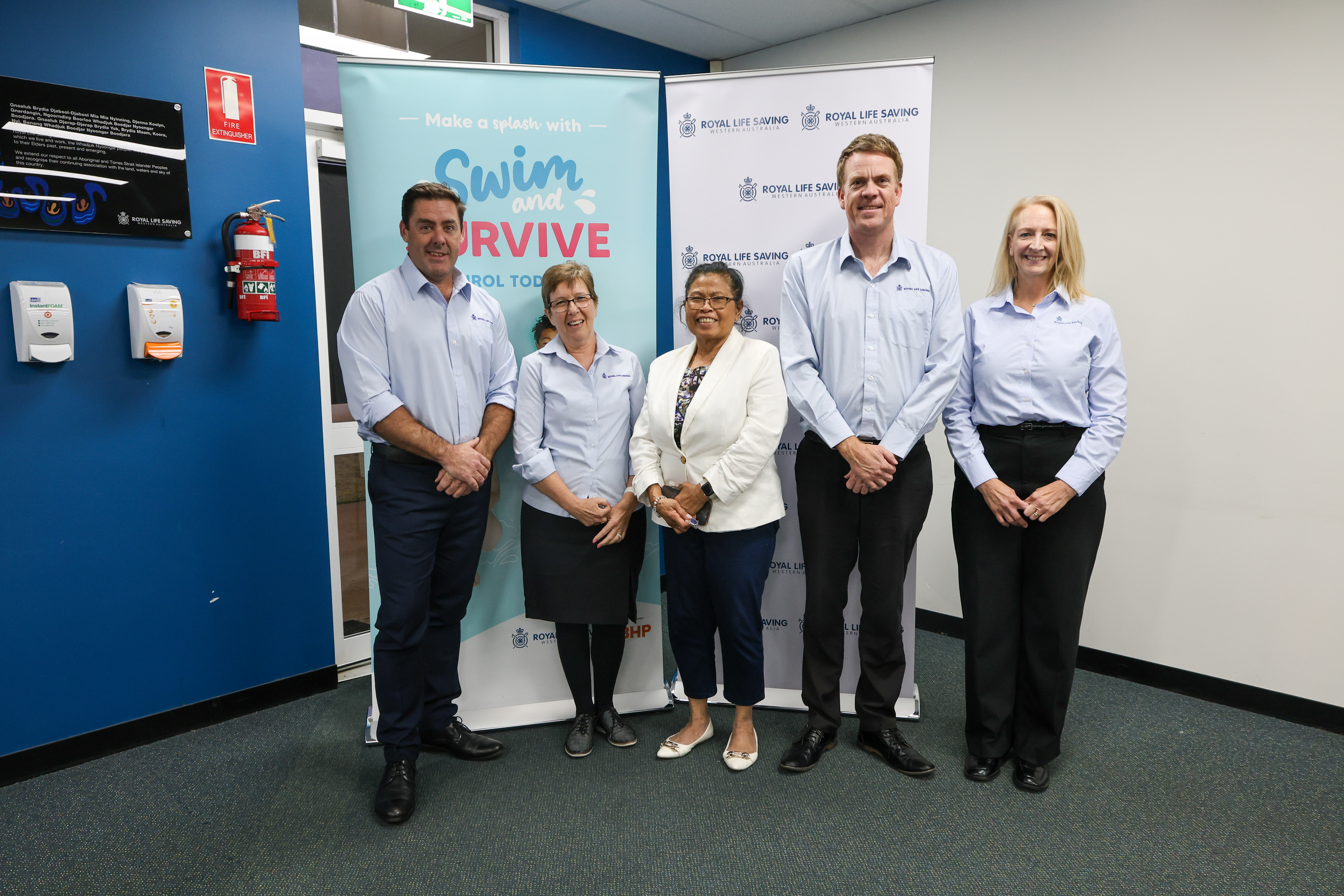 Five attendees pose in front of Royal Life Saving WA and Swim and Survive banners at the 2026 AGM.