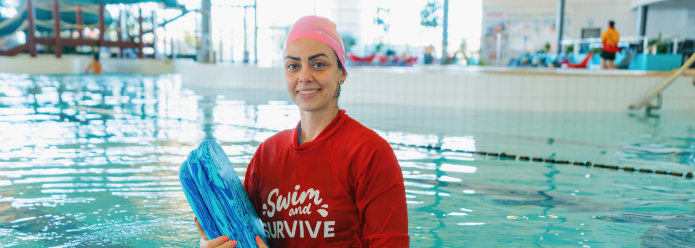 Royal Life Saving WA Swimming Instructor Atefeh Mahboob holds a kickboard while standing in the pool