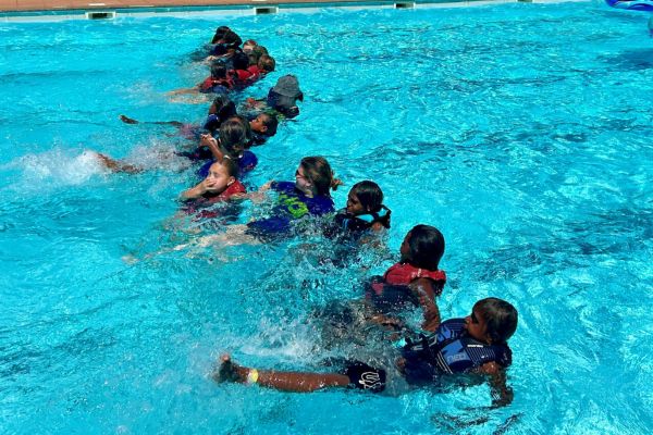Kids kicking in a line in the pool
