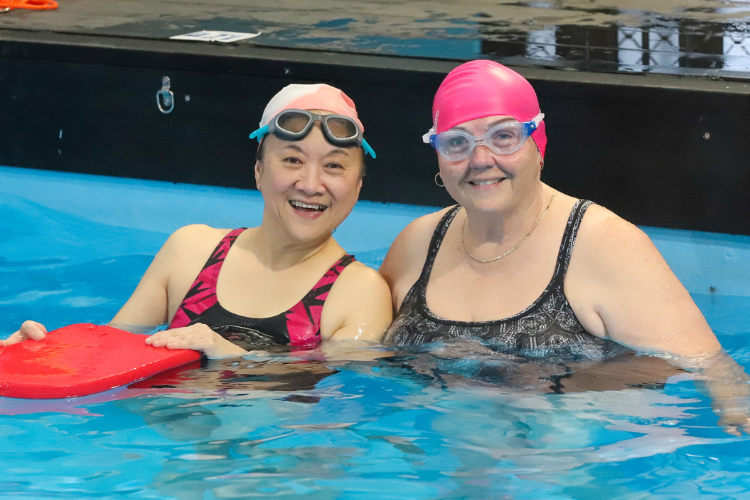 two women smiling during their swimming lesson