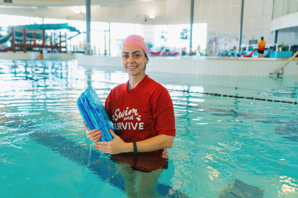 Royal Life Saving WA Swimming Instructor Atefeh Mahboob holds a kickboard while standing in the pool