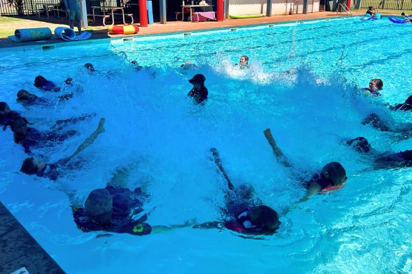 Kids wearing lifejackets kicking in a circle