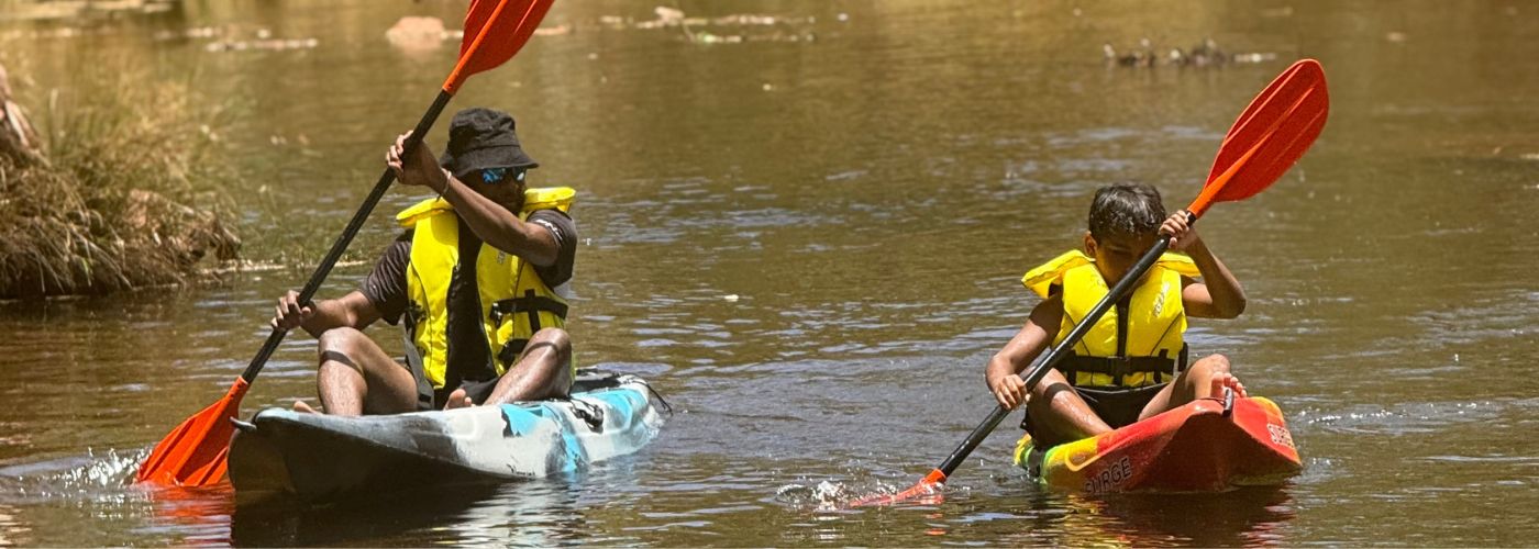 Two children paddling in kayaks