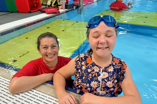 swimming student with a disability with her swimming teacher