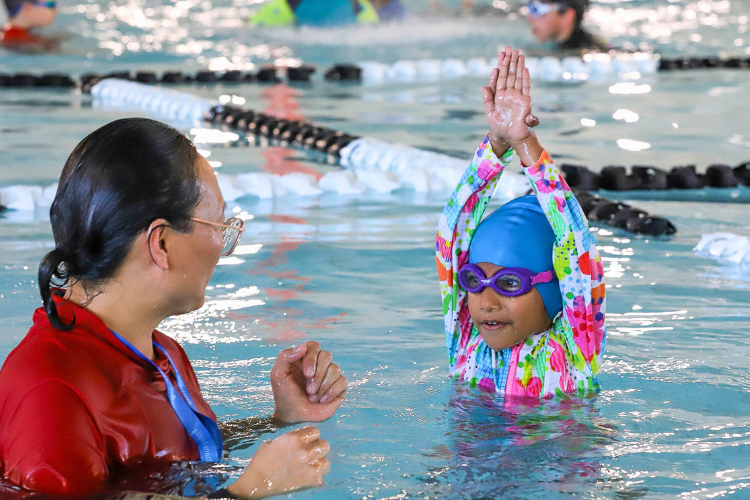 swimming teacher with a student in a pool
