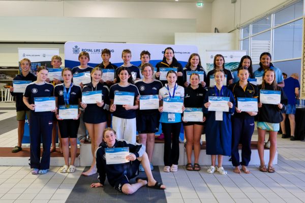 Junior pool lifesaving athletes pose with certificates during a presentation ceremony at the championships.