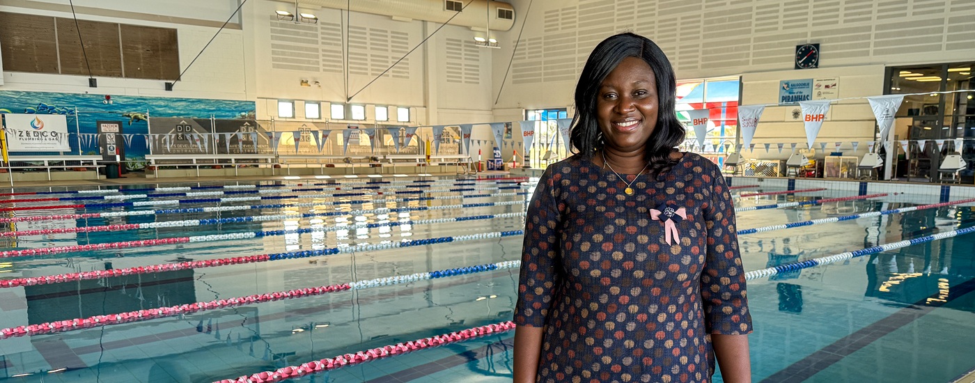 Multicultural swimming lesson participant Linda Larbi standing in front of the Goldfields Oasis indoor swimming pool