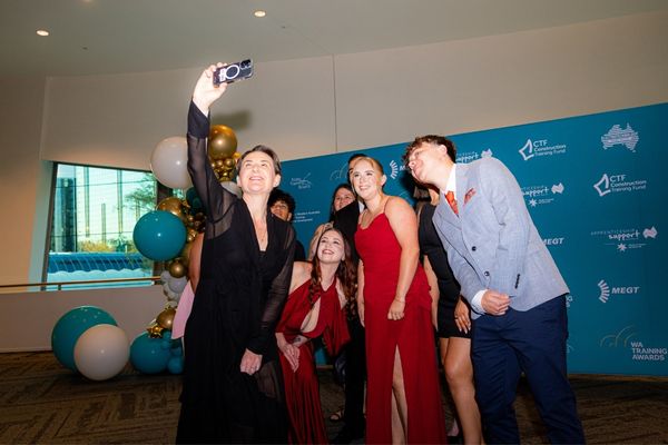 Annika Brown joins a group selfie in front of the WA Training Awards backdrop.